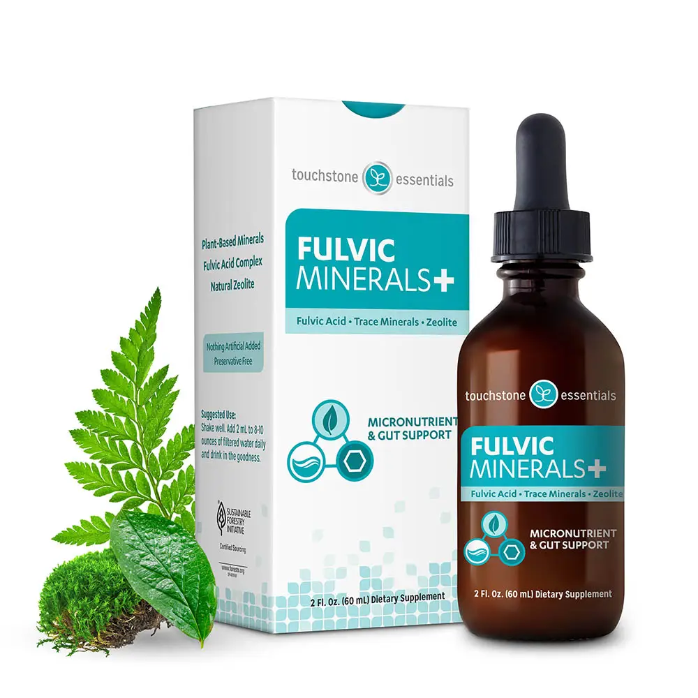 Touchstone Essentials Fulvic Minerals+, plant-based minerals with fulvic acid, trace minerals and natural zeolite, shown as an amber dropper bottle beside its retail box and fresh green ferns